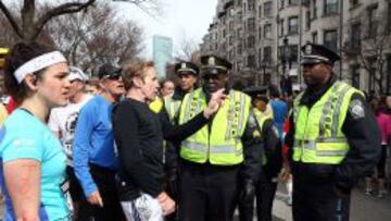Varios testigos y participantes en el Maratón de Boston conversan con las fuerzas de seguridad.