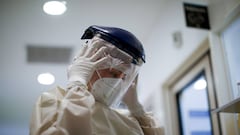 Healthcare worker Raquel Benitez puts on a face shield as she prepares to attend to a COVID-19 patient at the Eurnekian Ezeiza Hospital on the outskirts of Buenos Aires, Argentina, Tuesday, July 14, 2020, during a government-ordered lockdown to curb the spread of the new coronavirus. (AP Photo/Natacha Pisarenko)