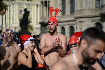 Participantes de la carrera a nado vestidos con gorros de Santa Claus o con cuernos de reno.