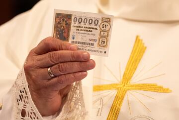 Un sacerdote sujeta un décimo (0000) durante el sorteo de Navidad.