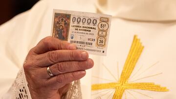 Un sacerdote sujeta un décimo (0000) durante el sorteo de Navidad.