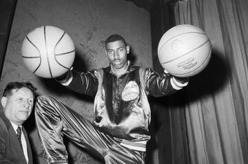 6/18/1958-New York, NY- Wilt &quot;The Stilt&quot; Chamberlain, twice All-American at the University of Kansas, bedazzles Harlem Globetrotters&#039; boss Abe Saperstein (R) with his basketball palming technique, after it was announced that Chamberlain had signed to play for the famous all-Negro team for a record high of $65,000 for one season. Chamberlain, who passed up his remaining year of eligibility at Kansas, becomes the draft choice of the pro Philadelphia Warriors next season.