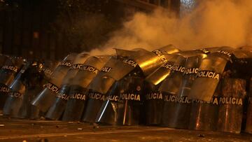 Police officers take cover with their shields during a clash with demonstrators during a protest against the decision of Congress to remove former President Martin Vizcarra, in Lima, Peru November 14, 2020. REUTERS/Sebastian Castaneda     TPX IMAGES OF THE DAY