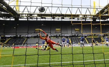 DORTMUND, GERMANY - MAY 16: Dortmund's Raphael Guerreiro scores the his side's 4th goal against Schalke's goalkeeper Markus Schubert during the Bundesliga match between Borussia Dortmund and FC Schalke 04 at Signal Iduna Park on May 16, 2020 in Dortmund, 