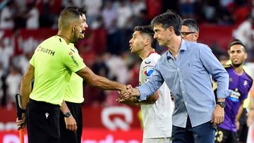 Sevilla's Argentinian defender Gonzalo Montiel (3L) talks with Spanish referee Jose Luis Pulido Santana (2L) as Real Valladolid's Spanish coach Jose Rojo 'Pacheta' (4L) shales hands with the assistant referee at the end of the Spanish League football match between Sevilla FC and Real Valladolid FC at the Ramon Sanchez Pizjuan stadium in Seville on August 19, 2022. (Photo by CRISTINA QUICLER / AFP)