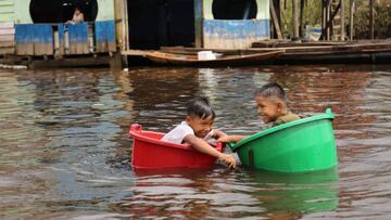 Children float on buckets on the Amazon River at Belen Port community in Iquitos, Peru on June 1, 2020 amid the new coronavirus pandemic. - Peru is facing an oxygen shortage to treat coronavirus patients, so the government plans to increase local production and make imports to ensure its supply, Health Minister VxEDctor Zamora reported. Peru, the second country in Latin America in the number of COVID-19 infections after Brazil, surpassed 170,000 confirmed cases on Monday, with more than 4,600 deaths, according to the official balance. (Photo by Cesar Von BANCELS / AFP)