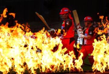 Calentitos parece que empiezan el partido Chris Gayle y Aaron Finch de los Renegades, que parecen atravesar las llamas en el partido Melbourne Renegades-Perth Scorchers de críquet en Melbourne, Australia.