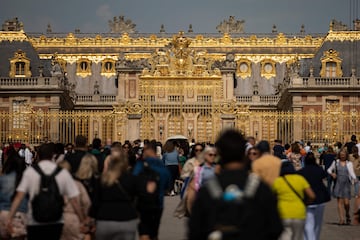 Visitors tour the premises in front of the golden gates of the Château de Versailles.