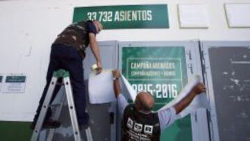 Operarios del Elche tapan la publicidad de la campaña de abonos para la siguiente temporada en el estadio Martínez Valero