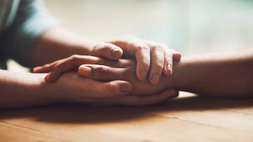Shot of two people holding hands in comfort CARICIAS