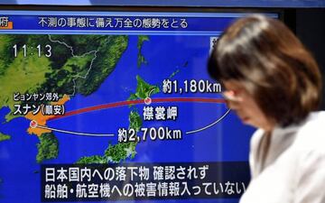 JAP01. TOKIO (JAPÓN), 28/08/2017.- Un peatón pasea frente a una pantalla de televisión en una calle que transmite la última hora del lanzamiento de un misil por parte de Corea del Norte hoy, martes 29 de agosto de 2017, en Tokio (Japón).