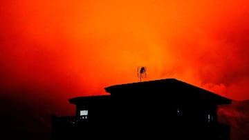 A house in Tajuya is seen with the Cumbre vieja volcano behind expelling lava and ash, on the Canary Island of La Palma, Spain, November 29, 2021. REUTERS/Borja Suarez