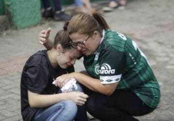 Fans of Brazil's soccer team Chapecoense mourn outside the Arena Conda stadium in Chapeco, Brazil, Tuesday, Nov. 29, 2016. A chartered plane that was carrying the Brazilian soccer team to the biggest match of its history crashed into a Colombian hillside and broke into pieces, Colombian officials said Tuesday. (AP Photo/Andre Penner)