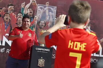 Seguidores de la selección española de fútbol se fotografían junto al trofeo. 