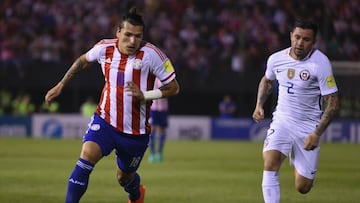 Paraguay&#039;s forward Federico Santander vies for the ball with Chile&#039;s defender Eugenio Mena  during the FIFA World Cup 2018 qualifier football match between Paraguay and Chile in Asuncion, Paraguay, on September 1, 2016. / AFP PHOTO / NORBERTO DUARTE