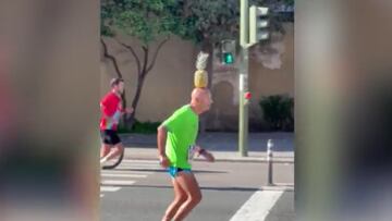 Corredor llega a la línea de meta con una piña en su cabeza