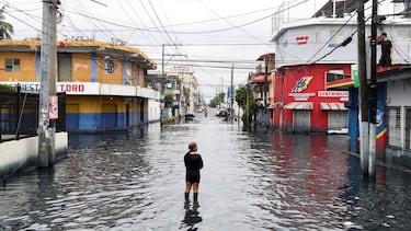 Una mujer se encuentra en una calle inundada por las lluvias provocadas por la tormenta tropical Melissa, en Santo Domingo, República Dominicana.