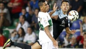 El defensa del Celta de Vigo Jonny Castro lucha un balón con el delantero brasileño del Elche Jonathas de Jesus, durante el partido de la sexta jornada de liga de Primera División, disputado esta noche en el Estadio Martínez Valero.