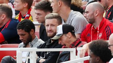 Mohamed Elneny, Skodran Mustafi y Mesut &Ouml;zil, en la grada durante un partido del Arsenal.