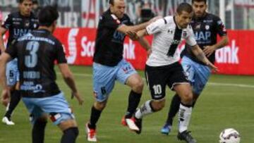 Riquero forcejea con Vecchio en el duelo ante Colo Colo, en el Monumental.