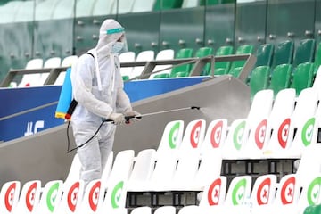 Soccer Football - AFC Champions League - Group E - FC Seoul v Beijing Guoan - Education City Stadium, Doha, Qatar - November 21, 2020 A staff member disinfects seats in the stands following the outbreak of the coronavirus disease (COVID-19) REUTERS/Ibrahe