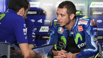 Movistar Yamaha MotoGP's Italian rider Valentino Rossi (R) talks to a team member during the last day of the 2017 MotoGP pre-season test at the Sepang International Circuit on February 1, 2017. / AFP PHOTO / Mohd RASFAN