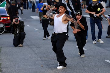 Un manifestante lanza una piedra durante una protesta contra las redadas federales de inmigración, en el centro de Los Ángeles.