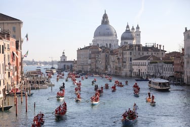 Personas vestidas de Papá Noel reman durantela  regata navideña en el Gran Canal de Venecia.