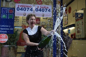 Una empleada de la administración situada en la calle Ledesma celebran que han vendido parte del número 04074 correspondiente al  'Segundo Premio’' del Sorteo Extraordinario de la Lotería de Navidad.