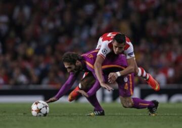Galatasaray's Turkish midfielder Hamit Altintop (L) vies with Arsenal's Chilean striker Alexis Sanchez (R) during the UEFA Champions League, Group D football match between Arsenal and Galatasaray at The Emirates Stadium in north London on October 1, 2014. Arsenal won the game 4-1. AFP PHOTO / ADRIAN DENNIS