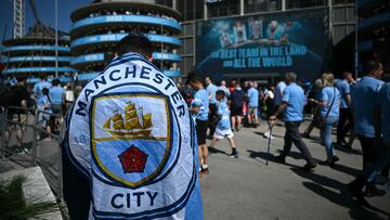 Un aficionado del Manchester City porta una bandera del equipo en frente del Etihad Stadium.