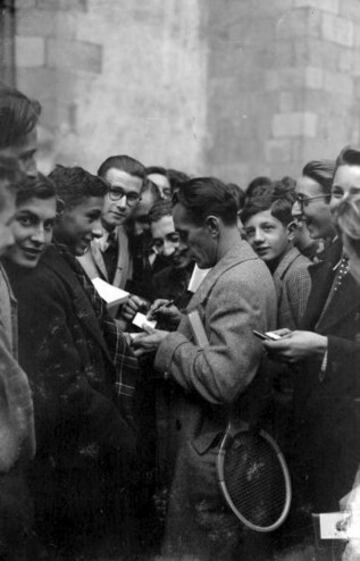 1943: Henri Cochet firmando autógrafos a un grupo de aficionados tras una conferencia sobre tenis en la escuela Gay-Lussac en Limoges.