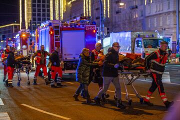 Los equipos de emergencia transportan a los heridos en camilla.