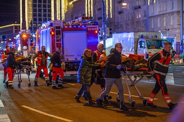 Los equipos de emergencia transportan a los heridos en camilla.