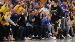 Stephen Curry #30 of the Golden State Warriors celebrates after making a basket as actor Rob Lowe reacts