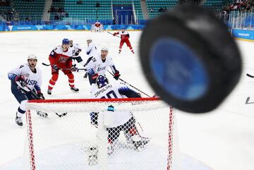 Los jugadores observan cómo el disco toca el cristal en el primer período de los cuartos de final de las eliminatorias masculinas entre la República Checa y los Estados Unidos en los Juegos Olímpicos de Invierno PyeongChang 2018.