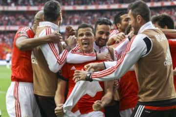 Los jugadores del  Benfica celebran sobre el terreno de juego su 33º título nacional, entrando en la historia del fútbol europeo. El equipo encarnado sumó los tres puntos de la jornada gracias a dos goles de Lima que le dejan a siete puntos de ventaja sobre el Sporting y a dieciocho del Oporto.