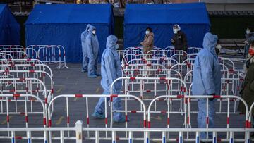 BEIJING, CHINA - JANUARY 25: Health workers wearing protective clothing guide people as they wait for nucleic acid tests to detect COVID-19 at a testing centre on January 25, 2022 in Beijing, China. While China has mostly contained the spread of COVID-19 