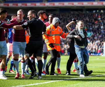 Un seguidor del Birmingham City Football Club ha saltado al terreno de juego durante el encuentro frente al Aston Villa y ha agredido al jugador del Jack Grealish, símbolo de los 'Villanos'.

