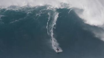 El surfista Kai Lenny surfeando una de las olas gigantes -de más de 15 metros- del histórico swell en Jaws (Pe'ahi, Maui, Hawái), en la parte más profunda de la ola, mientras el labio va cogiendo forma por encima suyo.