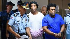 TOPSHOT - Brazilian retired football player Ronaldinho (C) and his brother Roberto Assis (R) arrive at Asuncion&#039;s Justice Palace to appear before a public prosecutor who will decide whether to grant them bail or not following their irregular entry to