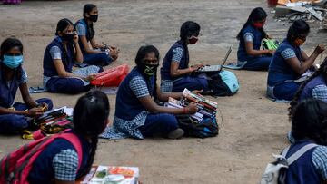 Students sit with course materials maintaining social distancing to collect text books before attending a tele-learning class at their home, an initiative set up by the Department of School Education to allow students from class 2 to 10 to continue with t