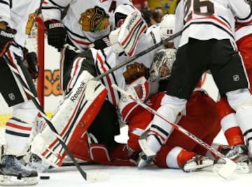 Corey Crawford de los Chicago Blackhawks involucrado en una tangana con Justin Abdelkader de los Detroit Red Wings.