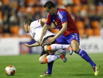 El defensa portugués del Valencia João Pereira disputa un balón con el centrocampista del Basilea David Degen.