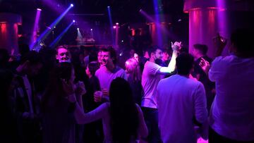 People dance in a nightclub in Barcelona on February 11, 2021. - In the northeastern region of Catalonia, nightlife venues were set to open at the stroke of midnight (2300 GMT) on February 11, 2022. In late December, the Catalan government put in place some of Spain's most restrictive measures to fight Omicron, imposing a night curfew from 1:00 am, closing nightlife venues and halving the capacity in bars and restaurants. (Photo by Pau BARRENA / AFP)