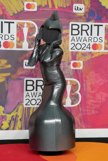 Una persona vestida con un curioso traje posa en la alfombra roja. 