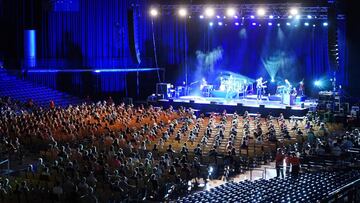 LEIPZIG, GERMANY - AUGUST 22: Participants wearing FFP2 protective face masks watch singer Tim Bendzko perform in the RESTART-19 Covid transmission risk assessment study in a concert setting at an indoor arena during the coronavirus pandemic on August 22, 2020 in Leipzig, Germany. The study, organized by the University Hospital of Halle (Saale), simulates a live concert venue with several thousand audience members in three different scenarios in order to develop risk reduction measures for large events. Participants wear tracer devices to track their movements and sensors measure aerosol currents in the arena. All participants had to undergo a Covid-19 test within the last 48 hours and test negative in order to take part. (Photo by Sean Gallup/Getty Images)