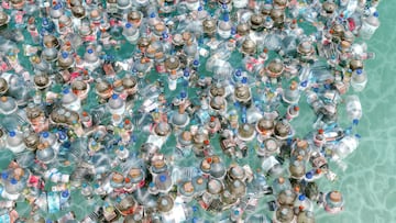 Diversos tipos de botellas y envases de plástico se acumulan en el mar.