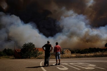 Los residentes locales Álvaro y Miguel observan cómo un incendio forestal se acerca a Congosta.