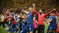 Slovakia's forward #09 Robert Bozenik (C), staff and teammates celebrate on the pitch after the UEFA Euro 2024 Group E football match between Slovakia and Romania at the Frankfurt Arena in Frankfurt am Main on June 26, 2024. (Photo by Angelos Tzortzinis / AFP)